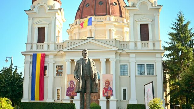 Church of the Annunciation and Statue of Emil Dandea in the centre of Targu Mures, Romania. Flowers and greenery