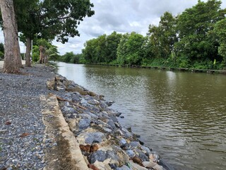 The canals deliver water for drainage during the rainy season and are also used for water transportation as well as agricultural uses. by using rocks arranged along the edge of the soil slide