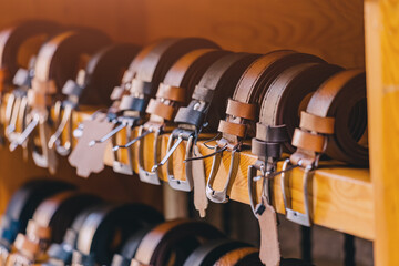 Many leather belts made by hand by a master tanner are put up for sale in a shop near the workshop