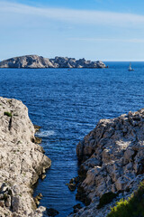 View of a small Calanque near Marseille, France. Typical southern France 'calanque' bay. Sailing boat in front of a bay in southern France. The rocky landscape of the Mediterranean coast of France. 