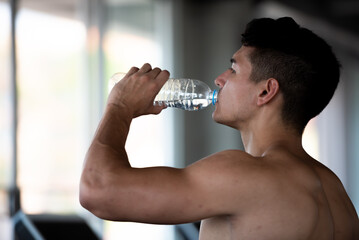 Young healthy sports man drinking water.