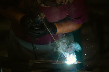 Industry worker welding iron pieces at work