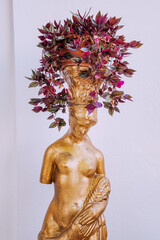 A flower pot with a plant in the form of a statue of the goddess of love Aphrodite in Greece