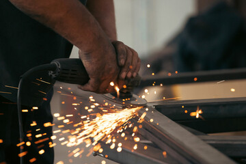 Close up on a man held an angle grinder to cut an iron with sparks