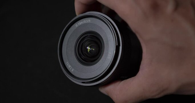 Front view of Sony Apsc lenses E 11mm f1.8 black background and light reflection photography apsc sony camera