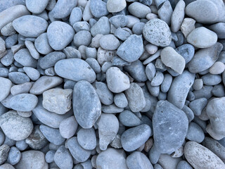 Round grey stones on the beach, pebbles pattern and texture, zen meditation, natural background.