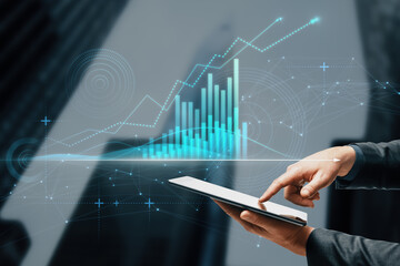 Close up of businessman hand pointing at tablet with abstract glowing polygonal business graph...