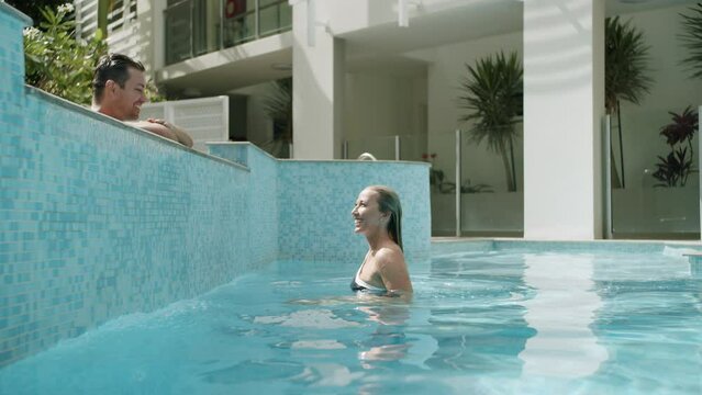 Attractive Female Emerging Wet From Blue Resort Swimming Pool Water, 4K Slow Motion