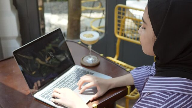 A Young Muslim Woman Typing On His Laptop With Blank Screen