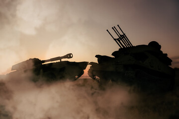 Obraz premium Silhouettes of armored fighting vehicle and tank on battlefield