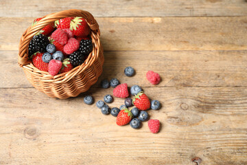 Mix of ripe berries on wooden table
