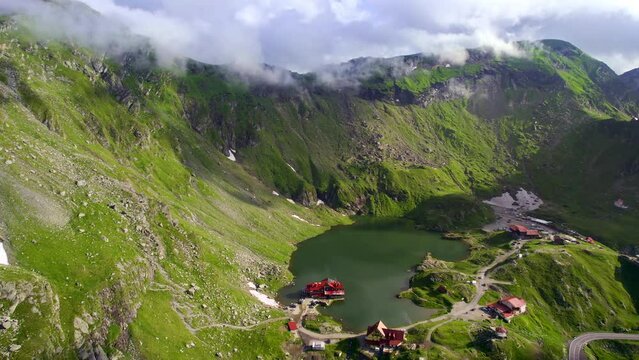 Aerial drone view of nature in Romania. Transfagarasan route in Carpathian mountains, Balea Lake resort and rocky slopes covered with greenery