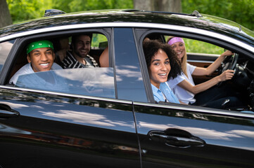 Group of friends driving in a car and looking excited