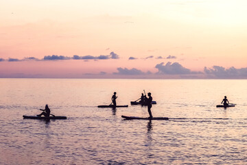 Travel.Silhouette man sea sup at sunset.outdoor travel.paddle standing, silhouette  man  beach  sunset. eco travel, taking care  your physical and mental health. Leisurely life and relaxation at sea. - obrazy, fototapety, plakaty