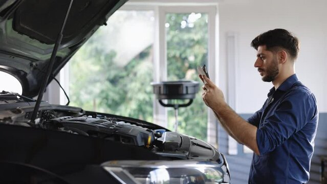 Specialist Inspecting Engine in Order to Find Broken Components. Shot for Animation of Car Service Manager Uses Tablet Computer with Futuristic Augmented Reality Diagnostics Software