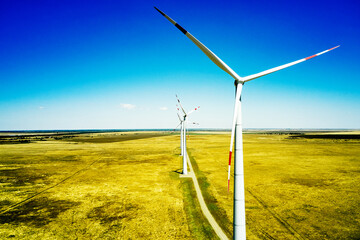 wind power plant in the steppe against the blue sky shooting from a drone
