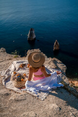 photo of a beautiful woman with long blond hair in a pink shirt and denim shorts and a hat having a...