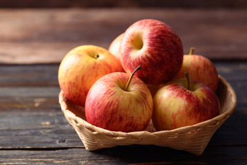 Red apple fruit in basket on wooden background, Healthy fruit
