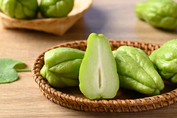 Chayote squash fruit in basket on wooden table, Organic vegetables