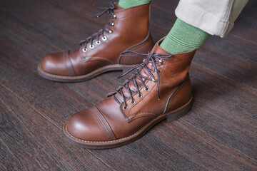 feet of man in green socks in stylish baroque leather boots on a wooden floor close-up - Powered by Adobe