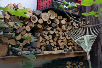 Conceded firewood in a pile. Stacked firewood on a wall behind the house. Ready to burn in the oven or chimney.