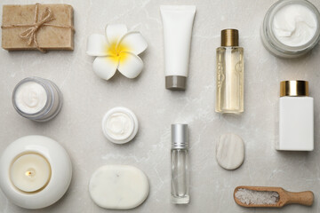 Flat lay composition with cosmetics and sea salt on grey marble table. Spa treatment