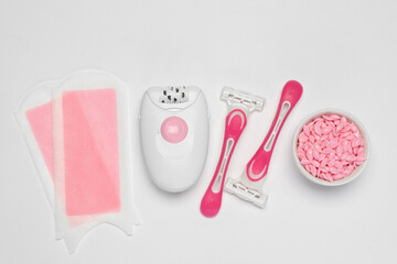 Modern epilator and other hair removal products on white background, flat lay