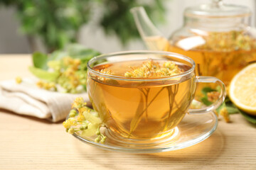 Cup of tea with linden blossom on wooden table