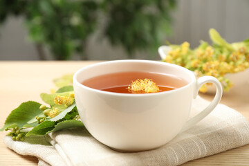 Cup of tea with linden blossom on wooden table