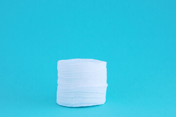Cotton pads in stack. Turquoise background.