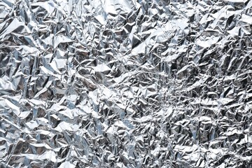 Crumpled silver foil as background, closeup view