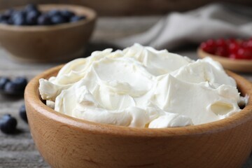 Tasty cream cheese in wooden bowl, closeup