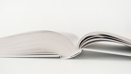 Opened white book on white background