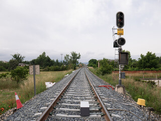 High railway signal for the E2 entrance to the Monforte de Lemos station indicating a stop (Red) and a yellow sign indicating "start, maneuvering area" next to its associated beacon