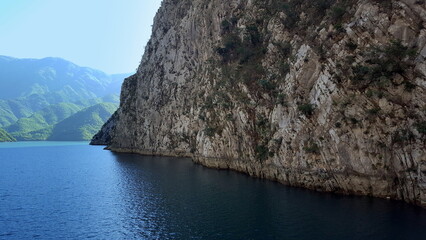 Albania, Lake Koman is a reservoir on the Drin River in northern Albania, surrounded by dense forested hills, vertical slopes, deep gorges and a narrow valley