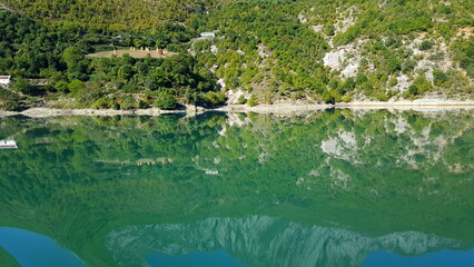 Albania, Lake Koman is a reservoir on the Drin River in northern Albania, surrounded by dense forested hills, vertical slopes, deep gorges and a narrow valley