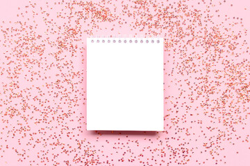 White clear notepad mockup with shiny crystals confetti on a pink background.