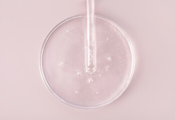 glass pipette serum gel closeup in petri dish on beige background