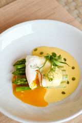 Poached egg with hollandaise sauce and asparagus.
