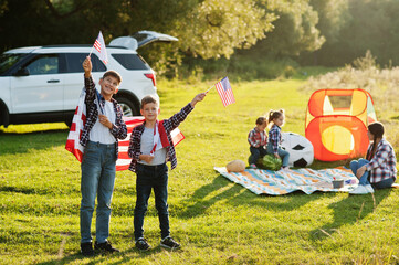 American family. Mother and four kids. With USA flags. America celebrating.