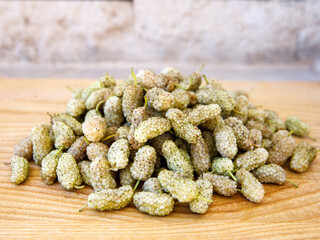 Fresh white mulberry on wooden background. (Morus alba) Side view close-up. Summer organic fruits. Mulberry background