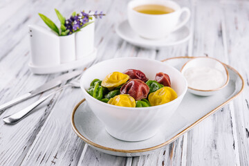 Cooked multi-colored tortellini dumplings close-up in a bowl