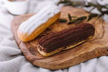 Tasty dessert, two eclairs with vanilla and chocolate cream laying