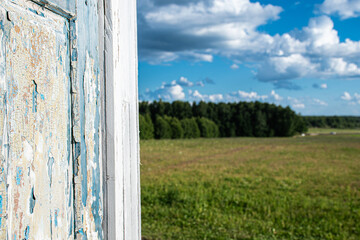 landscape view, green field and blue sky with white clouds and old antique door