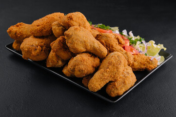 Deep fried chicken on black plate