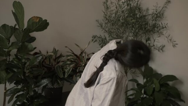 Beautiful Asian young woman shaking her head and pigtail, looks unhappy, lost due to unpleasant thoughts. Beauty suffers from life's problems. Filmed in cinematic style