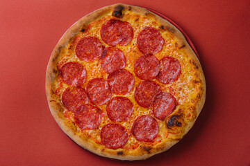 Fresh tasty pizza with pepperoni on red background