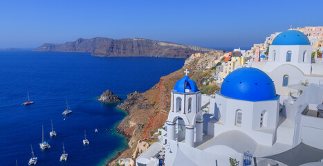 Santorini, Greece. Lovely view of Oia village with traditional famous blue domed church on the...