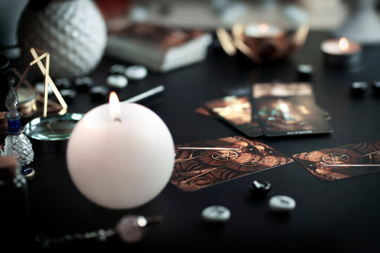 Blurred still life with vintage esoteric magic objects and old tarot cards on witch table altar for mystic rituals and fortune telling.