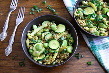Dish of pearl barley, broad beans, beans and zucchini. Stewed vegetables with porridge. Vegetarian cooking